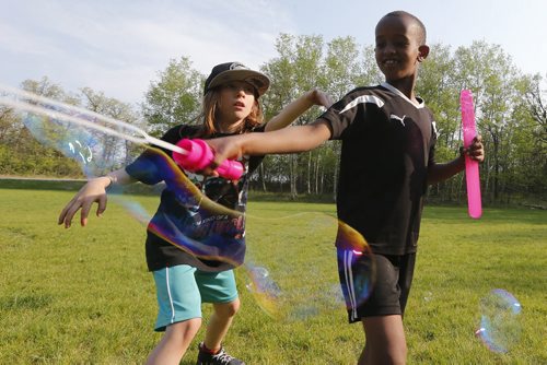 May 26, 2015 - 150526  -  Gavin Flattery-Neumann (9) (L) and Ahmed Siaig (7) play with bubbles at a family BBQ at Assiniboine Park Tuesday, May 26, 2015. John Woods / Winnipeg Free Press
