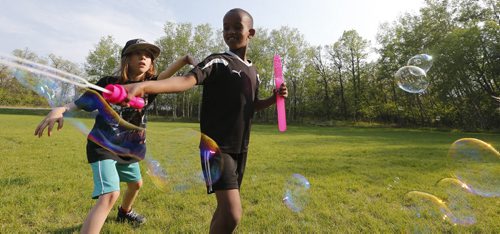 May 26, 2015 - 150526  -  Gavin Flattery-Neumann (9) (L) and Ahmed Siaig (7) play with bubbles at a family BBQ at Assiniboine Park Tuesday, May 26, 2015. John Woods / Winnipeg Free Press