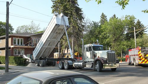 A dump truck is caught up in electrical wires causing delays in traffic along Academy and Wellington Crescent close to Harrow Ave. Wednesday morning.  150527 May 27, 2015 Mike Deal / Winnipeg Free Press