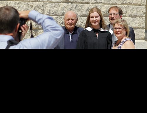 University of Manitoba convocation. Before the actual convocation that starts at 3pm grads took photos with friends and family. Melissa Pauls gets a passer by to take a snap of her and her family before grad. NO IDS ON ALL THE FAMILY. BORIS MINKEVICH/WINNIPEG FREE PRESS May 27, 2015