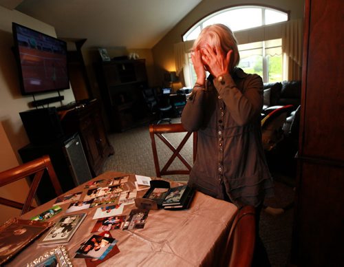 Standing at her dining room table covered in snapshots, Joanne Rislund covers her face as she recalls memories good and bad about her father Frank ALexander, an Alziemer's patient killed by another senior in a Winnipeg Nursing home.See Carol Sanders post enquiry story. May 28, 2015 - (Phil Hossack / Winnipeg Free Press)