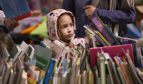Six-year-old Keira Emmers checks out some books at the Herntier family garage sale at the St. Andrew CC Saturday afternoon which runs through till 5 Sunday. See Alex Paul story.   May 30, 2015 Ruth Bonneville / Winnipeg Free Press