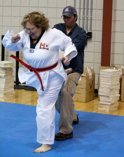 A man assisting in a board breaking contest is accidentally kicked during the Iron Fist Taekwondo Club Challenge at the University of Manitoba, Saturday, May 30, 2015. (TREVOR HAGAN/WINNIPEG FREE PRESS)