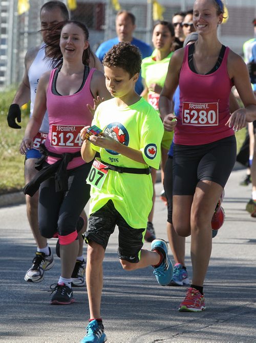 Alex Sala, 11, works on a rubics cube while taking part in the Royal Canadian Air Force Family Run/Walk at 17 Wing Airforce Base Sunday morning.  150531 May 31, 2015 Mike Deal / Winnipeg Free Press