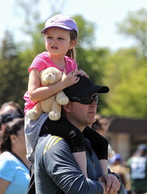 Aleda McDonald, 4, with her father Colin make there way through the crowd at the 29th annual Teddy Bears' Picnic at Assiniboine Park. The event brings around 30,000 people to the park, mostly kids with their stuffed toys that are damaged and need fixing. The money raised goes towards the Childrens Hospital Foundation of Manitoba.  150531 May 31, 2015 Mike Deal / Winnipeg Free Press