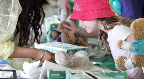 Reagan Jaworski, 8, watches as her teddy bear is treated in the medical centre by a doctor at the Teddy Bears' Picnic at Assiniboine Park. The event brings around 30,000 people to the park, mostly kids with their stuffed toys that are damaged and need fixing. The money raised goes towards the Childrens Hospital Foundation of Manitoba.  150531 May 31, 2015 Mike Deal / Winnipeg Free Press