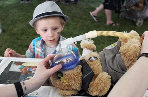 Nathan James, 3, watches as his teddy bear is treated by a doctor at the medical centre at the Teddy Bears' Picnic at Assiniboine Park. The event brings around 30,000 people to the park, mostly kids with their stuffed toys that are damaged and need fixing. The money raised goes towards the Childrens Hospital Foundation of Manitoba.  150531 May 31, 2015 Mike Deal / Winnipeg Free Press