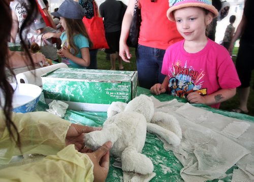 Hadley Umrau, 6, watches as her stuffy is treated by a doctor in the medical centre at the Teddy Bears' Picnic at Assiniboine Park. The event brings around 30,000 people to the park, mostly kids with their stuffed toys that are damaged and need fixing. The money raised goes towards the Childrens Hospital Foundation of Manitoba.  150531 May 31, 2015 Mike Deal / Winnipeg Free Press