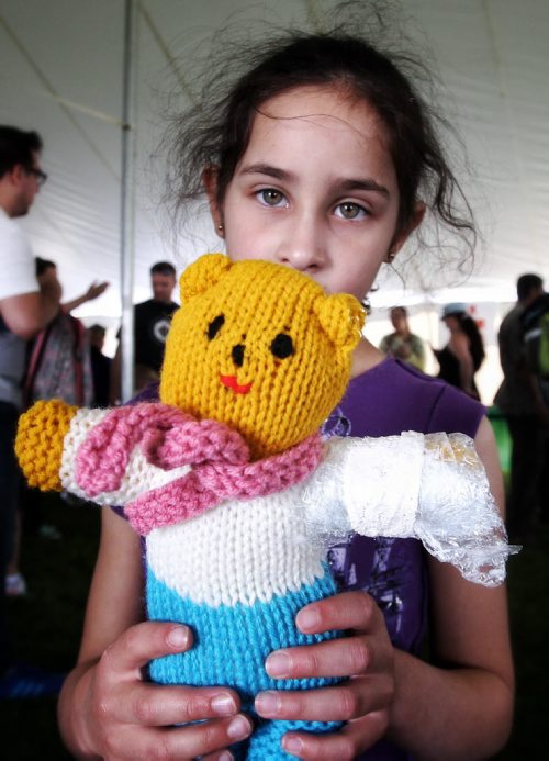 Amalia Alfonso, 6, with her stuffy after it was treated by a doctor in the medical centre at the Teddy Bears' Picnic at Assiniboine Park. The event brings around 30,000 people to the park, mostly kids with their stuffed toys that are damaged and need fixing. The money raised goes towards the Childrens Hospital Foundation of Manitoba.  150531 May 31, 2015 Mike Deal / Winnipeg Free Press