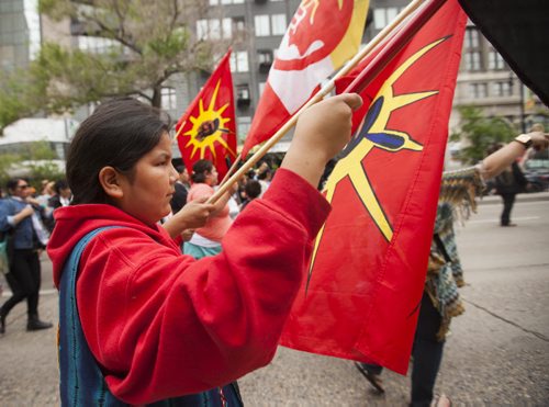 Darnel Wood holds a flag at the Walk for Reconciliation on Tuesday, June 2, 2015.  The march went through downtown from the University of Winnipeg, and finished at the Thunderbird House for a feast and pipe ceremony. Mikaela MacKenzie / Winnipeg Free Press