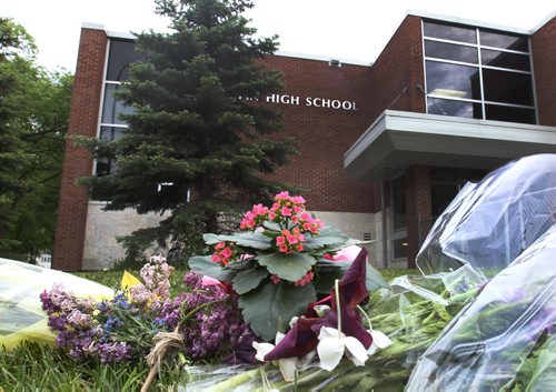 Small bunches of flowers left from last night at the scene of yesterdays stabbing homicide outside Kelvin High School in Winnipeg Standup Photo- June 03, 2015   (JOE BRYKSA / WINNIPEG FREE PRESS)