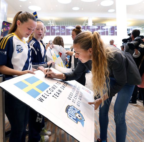 Charlotte Rolhin, a member of Team Sweden signs a poster for Jax Correia a player on the St. Charles Force after Team Sweden arrived at the James A Richardson International Airport Wednesday to compete in the FIFA Womens World Cup Canada 2015.The fifth ranked Sweden will have a few days to train before they kick-off their tournament run in Winnipeg with Group D matches against Nigeria and the USA starting 8 June.   Wayne Glowacki / Winnipeg Free Press June 3 2015