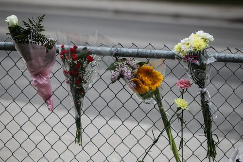 A memorial of flowers set up outside the doors to Kelvin High School Wednesday the day close to where former student Brett Bourne was stabbed. Bourne died in hospital from his injuries. 150603 - Wednesday, June 03, 2015 -  MIKE DEAL / WINNIPEG FREE PRESS