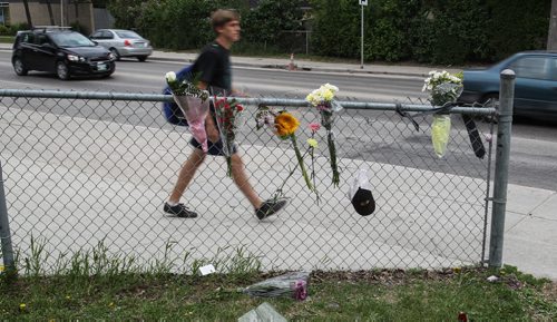 Students walk past a memorial of flowers set up outside the doors to Kelvin High School Wednesday the day close to where former student Brett Bourne was stabbed. Bourne died in hospital from his injuries. 150603 - Wednesday, June 03, 2015 -  MIKE DEAL / WINNIPEG FREE PRESS