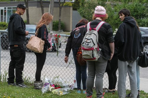 Students gather briefly amongst a memorial of flowers set up outside the doors to Kelvin High School Wednesday the day close to where former student Brett Bourne was stabbed. Bourne died in hospital from his injuries. 150603 - Wednesday, June 03, 2015 -  MIKE DEAL / WINNIPEG FREE PRESS