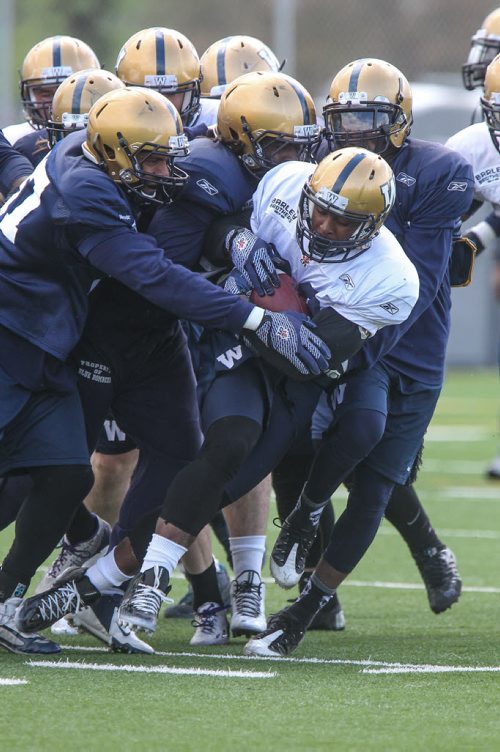 Cameron Marshall (32) is mobbed by the blue d-line during day 4 of the Winnipeg Blue Bomber training camp Wednesday morning. 150603 - Wednesday, June 03, 2015 -  MIKE DEAL / WINNIPEG FREE PRESS