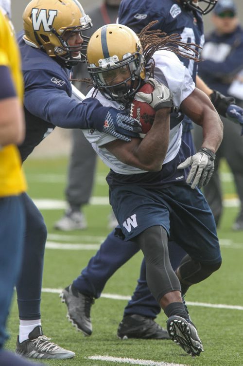 Paris Cotton (34) evades Deantre Harlan (94) during day 4 of the Winnipeg Blue Bomber training camp Wednesday morning. 150603 - Wednesday, June 03, 2015 -  MIKE DEAL / WINNIPEG FREE PRESS