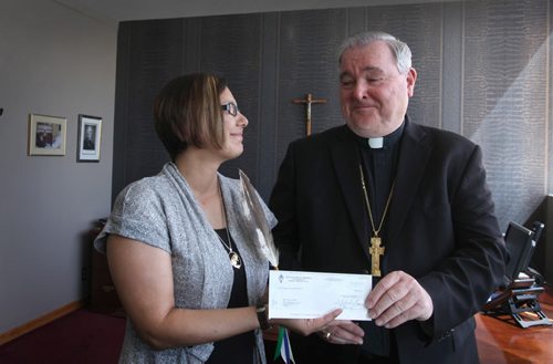 Archbishop Richard Gagnon presents donation cheque of $60,000 to Lisa Raven, Executive Director of Returning to Spirit  at the Catholic Centre Thursday morning in Wpg.  The money was collected from its Centennial Mass, attended by 13,000 faithful at MTS Centre May 3 and will go toward this Aboriginal non-profit charitable organization providing reconciliation and healing workshops that  bring Aboriginals and Non-Aboriginals together. See Alex Paul story.   June 04, 2015 Ruth Bonneville / Winnipeg Free Press
