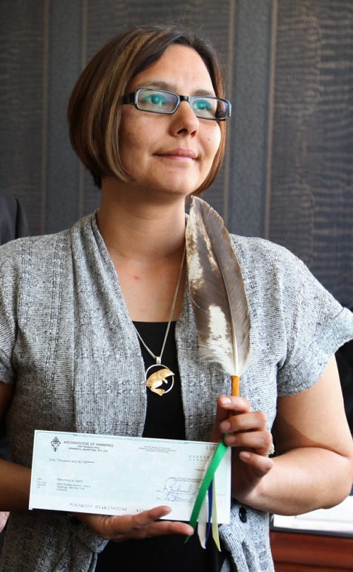 Lisa Raven, Executive Director of Returning to Spirit holds a donation cheque of $60,000 given to her by Archbishop Richard Gagnon  at the Catholic Centre Thursday morning. The money was collected from its Centennial Mass, attended by 13,000 faithful at MTS Centre May 3 and will go toward this Aboriginal non-profit charitable organization providing reconciliation and healing workshops that  bring Aboriginals and Non-Aboriginals together. See Alex Paul story.   June 04, 2015 Ruth Bonneville / Winnipeg Free Press