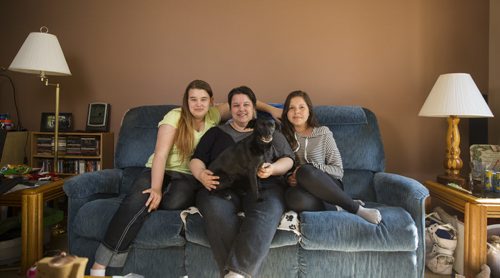 Kassandra Dubyts (left), Sherri Dubyts, and Kira Sainnawap-Dubyts sit on the couch in their living room on Thursday, June 4, 2015. Both Kassandra and Kira have gone to camps with the Sunshine Fund before, and are looking forward to going again this summer. Mikaela MacKenzie / Winnipeg Free Press