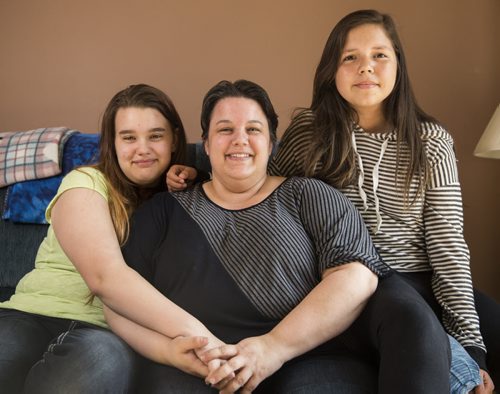 Kassandra Dubyts (left), Sherri Dubyts, and Kira Sainnawap-Dubyts sit on the couch in their living room on Thursday, June 4, 2015. Both Kassandra and Kira have gone to camps with the Sunshine Fund before, and are looking forward to going again this summer. Mikaela MacKenzie / Winnipeg Free Press