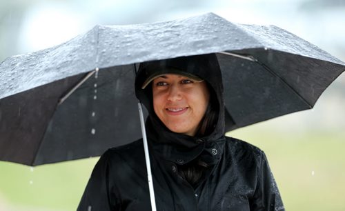 An official tries to stay dry during the MSHAA Provincial Track and Field Championships during heavy rain, at University Stadium at the University of Manitoba, Saturday, June 6, 2015. (TREVOR HAGAN/WINNIPEG FREE PRESS)