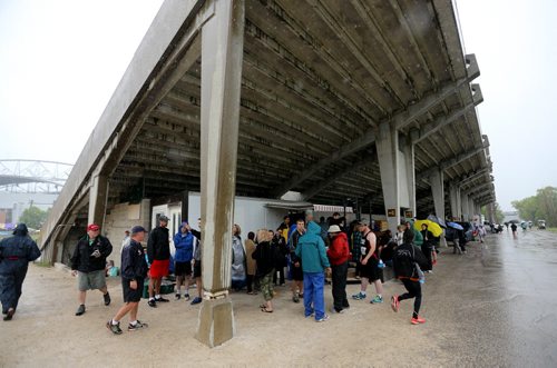 Spectators and athletes take cover under the stands during MSHAA Provincial Track and Field Championships during heavy rain, at University Stadium at the University of Manitoba, Saturday, June 6, 2015. (TREVOR HAGAN/WINNIPEG FREE PRESS)