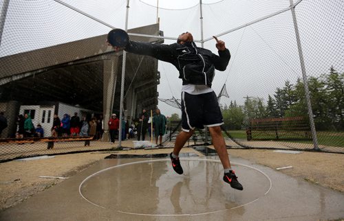 Colin van Kommer warms up for his discuss competition at the MSHAA Provincial Track and Field Championships during heavy rain, at University Stadium at the University of Manitoba, Saturday, June 6, 2015. (TREVOR HAGAN/WINNIPEG FREE PRESS)