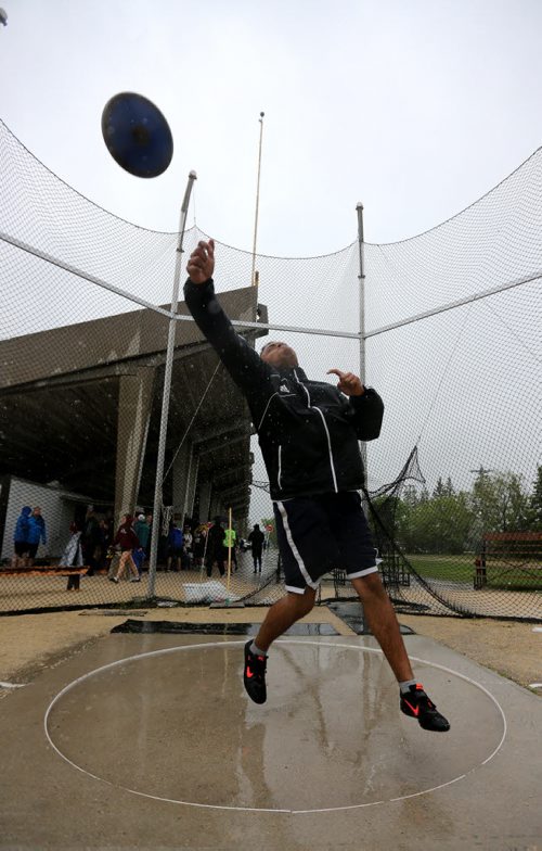 Colin van Kommer warms up for his discuss competition at the MSHAA Provincial Track and Field Championships during heavy rain, at University Stadium at the University of Manitoba, Saturday, June 6, 2015. (TREVOR HAGAN/WINNIPEG FREE PRESS)