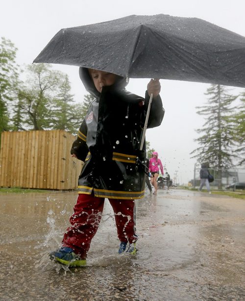 Brady Winslow, 3, splashes his way to the stands during MSHAA Provincial Track and Field Championships during heavy rain, at University Stadium at the University of Manitoba, Saturday, June 6, 2015. (TREVOR HAGAN/WINNIPEG FREE PRESS)