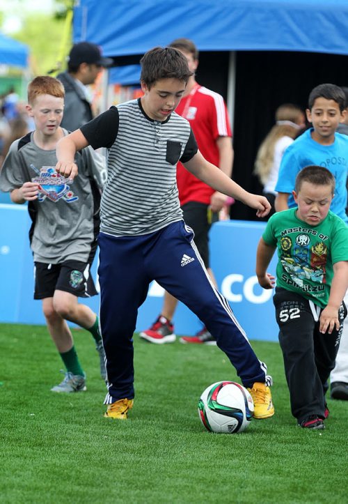 Kids play a pick-up game of soccer at the kick-off of the Women's World Cup game, Canada vs China, that was telecast live outside the stadium Saturday.   Standup photo.   June 06, 2015 Ruth Bonneville / Winnipeg Free Press