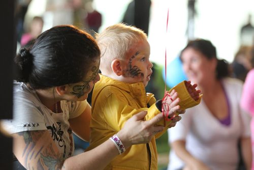 21-month old Isaiah Bruce smiles as he watches the entertainment on stage with his mom Sabrina at Kid Fest Saturday  at the Forks.   Standup photo    June 06, 2015 Ruth Bonneville / Winnipeg Free Press
