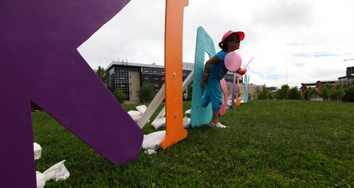 Lily Labossiere crawls through the letter "D" of the "Kids Fest" sign on top of the hill at the Forks for Kids Fest .Saturday. Standup photo    June 06, 2015 Ruth Bonneville / Winnipeg Free Press