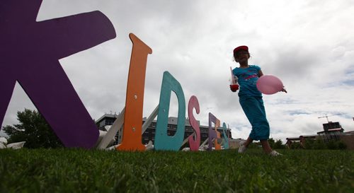 Lily Labossiere plays next to the  "Kids Fest" sign on top of the hill at the Forks for Kids Fest .Saturday. Standup photo    June 06, 2015 Ruth Bonneville / Winnipeg Free Press