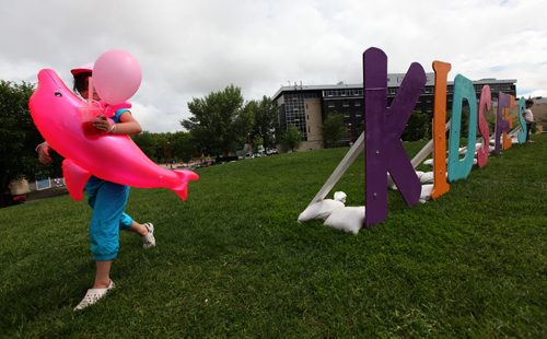 Lily Labossiere plays next to the  "Kids Fest" sign on top of the hill at the Forks for Kids Fest .Saturday. Standup photo    June 06, 2015 Ruth Bonneville / Winnipeg Free Press