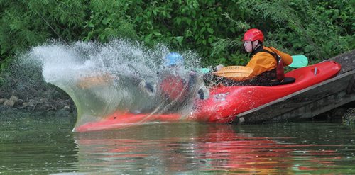 Matthias Penner (blue helmet) and Alex Martin (red helmet) with the Manitoba Whitewater Club go down the slide in a two-person kayak at FortWhyte Alive during the MEC Paddlefest.  150607 June 7, 2015 MIKE DEAL / WINNIPEG FREE PRESS