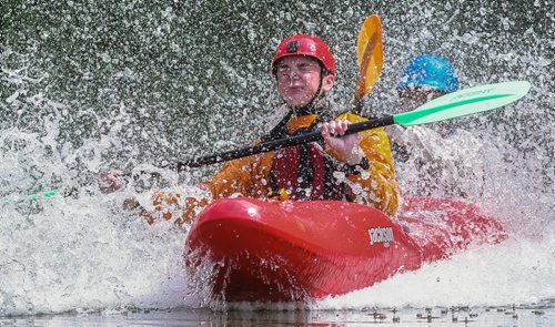 Alex Martin (red helmet) and Matthias Penner (blue helmet) ride down the slide in a double kayak during the MEC Paddlefest at FortWhyte Alive Sunday. 150607 - Sunday, June 07, 2015 -  MIKE DEAL / WINNIPEG FREE PRESS