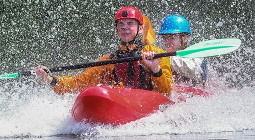 Alex Martin (red helmet) and Matthias Penner (blue helmet) ride down the slide in a double kayak during the MEC Paddlefest at FortWhyte Alive Sunday. 150607 - Sunday, June 07, 2015 -  MIKE DEAL / WINNIPEG FREE PRESS