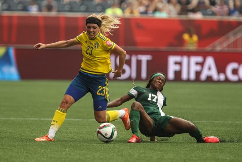 Sweden's Elin Rubensson (23) gains control of the ball over Nigeria's Francisca Ordega (17) during the first half of FIFA Women's World Cup soccer action in Winnipeg on Monday, June 8, 2015. 150608 - Monday, June 08, 2015 -  MIKE DEAL / WINNIPEG FREE PRESS