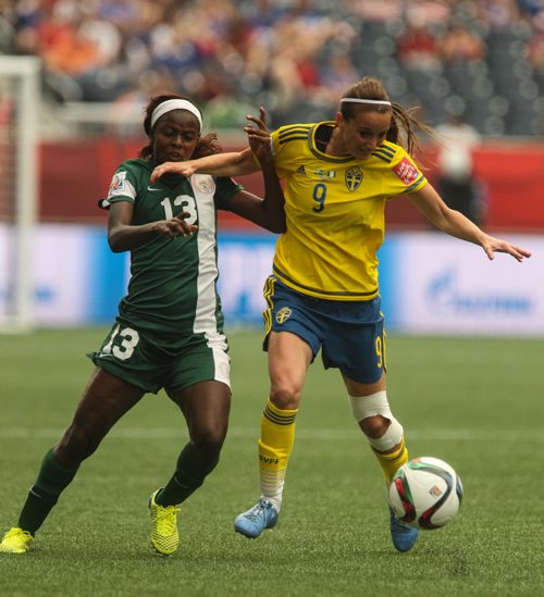 Sweden's Kosovare Asllani (9) and Nigeria's Ngozi Okobi (13) battle for the ball during the first half of FIFA Women's World Cup soccer action in Winnipeg on Monday, June 8, 2015. 150608 - Monday, June 08, 2015 -  MIKE DEAL / WINNIPEG FREE PRESS