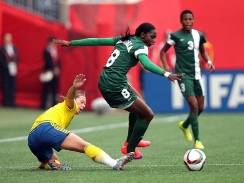 Sweden's #16 Lina Nilsson kicks the feet out from under Nigeria's # 8 Asisat Oshoala Monday afternoon in Women's World Cup Soccer action in Winnipeg. June 8, 2015 - (Phil Hossack / Winnipeg Free Press)