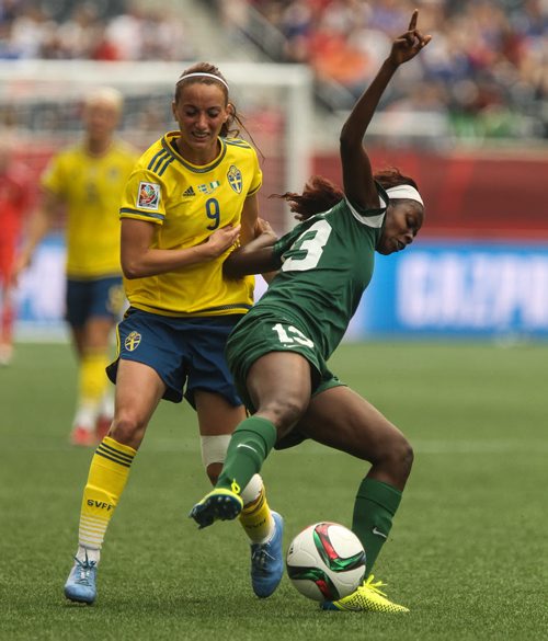 Sweden's Kosovare Asllani (9) and Nigeria's Ngozi Okobi (13) battle for the ball during the first half of FIFA Women's World Cup soccer action in Winnipeg on Monday, June 8, 2015. 150608 - Monday, June 08, 2015 -  MIKE DEAL / WINNIPEG FREE PRESS