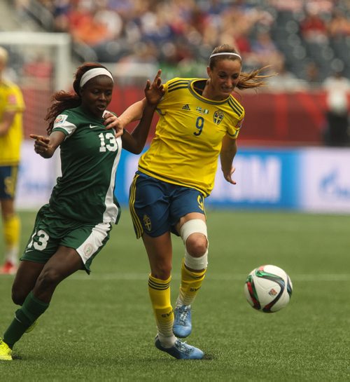 Sweden's Kosovare Asllani (9) and Nigeria's Ngozi Okobi (13) battle for the ball during the first half of FIFA Women's World Cup soccer action in Winnipeg on Monday, June 8, 2015. 150608 - Monday, June 08, 2015 -  MIKE DEAL / WINNIPEG FREE PRESS