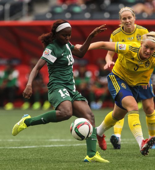 Nigeria's Ngozi Okobi (13) kicks the ball past Sweden's Nilla Fischer (5) into the net for Nigeria's first goal during the second half of FIFA Women's World Cup soccer action in Winnipeg on Monday, June 8, 2015. 150608 - Monday, June 08, 2015 -  MIKE DEAL / WINNIPEG FREE PRESS