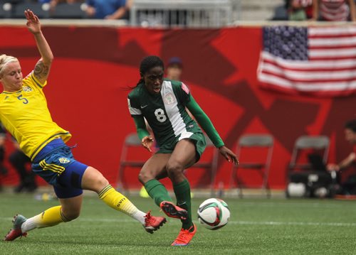 Nigeria's Asisat Oshoala (8) kicks the ball towards the net for a goal while Sweden's Nilla Fischer (5) tries to make a stop during the second half of FIFA Women's World Cup soccer action in Winnipeg on Monday, June 8, 2015. 150608 - Monday, June 08, 2015 -  MIKE DEAL / WINNIPEG FREE PRESS