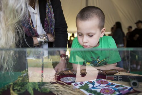 Kaileb Hornbrook, six, looks at artifacts representing the treaties as his mom receives their treaty cheques at the Forks in Winnipeg on Tuesday, June 9, 2015. Mikaela MacKenzie / Winnipeg Free Press