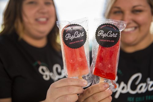 Alana Fiks (left) and Angela Farkas showcase their freshly made popsicles in a cart at the Forks in Winnipeg on Tuesday, June 9, 2015.  The two have been in business for less than a year, but they feel that there is a niche for their refreshing sweets. Mikaela MacKenzie / Winnipeg Free Press
