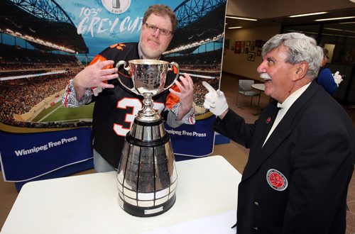 LOCAL -Doug Spiers horses around with Grey Cup handler Dan Maloney in the foyer of the Winnipeg Free Press. Doug column. BORIS MINKEVICH/WINNIPEG FREE PRESS June 10, 2015