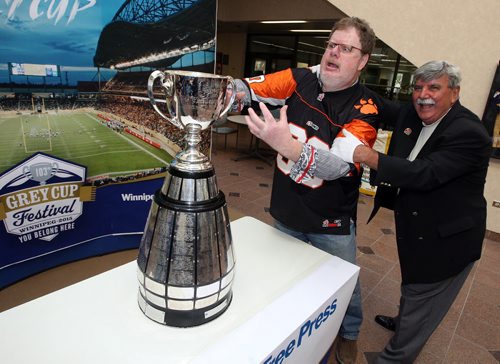 LOCAL -Doug Spiers horses around with Grey Cup handler Dan Maloney in the foyer of the Winnipeg Free Press. Doug column. BORIS MINKEVICH/WINNIPEG FREE PRESS June 10, 2015