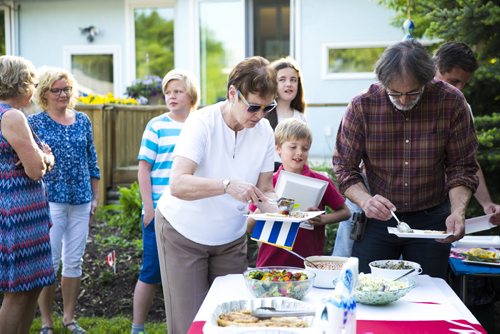 Guests serve themselves at a fish fry for soccer fans at Sonja Lundstrom's house on Wednesday, June 10, 2015.  Fried pickerel, maple beans, coleslaw, and homemade bread all made for a typically Canadian meal to serve to the Swedish fans. Mikaela MacKenzie / Winnipeg Free Press